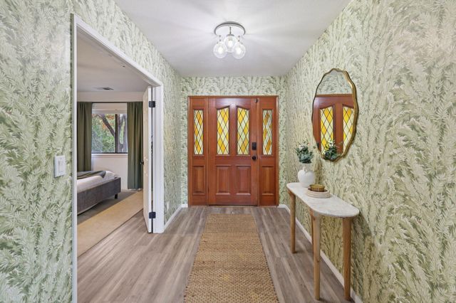 a living room with furniture kitchen view and a wooden floor