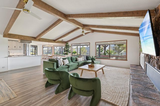 a bedroom with a bed lamp and a large window with wooden floor