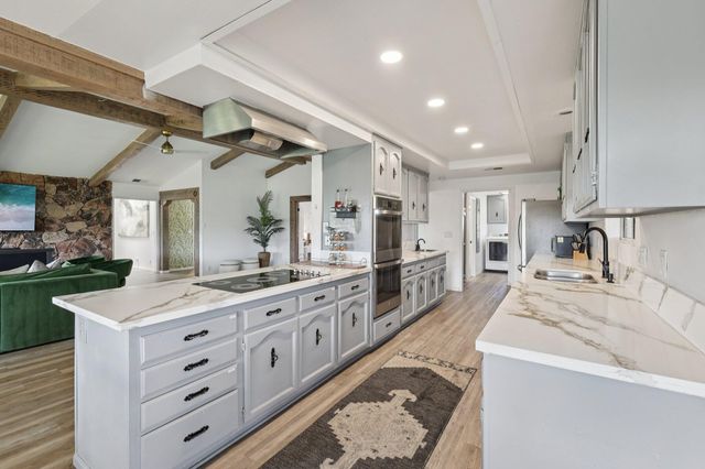 a kitchen with stainless steel appliances granite countertop a sink stove and wooden cabinets