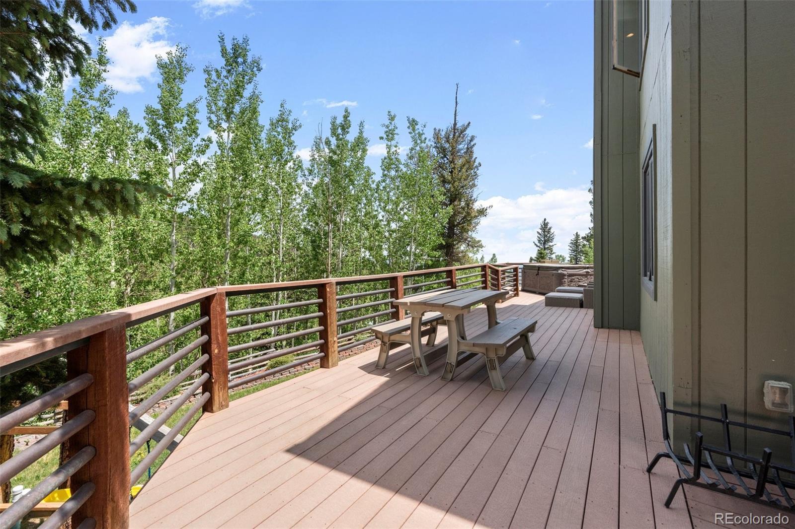 1682 Sinton Road Evergreen, CO 80439 - Photo 15 of 40 a view of a balcony with wooden floor and outdoor seating