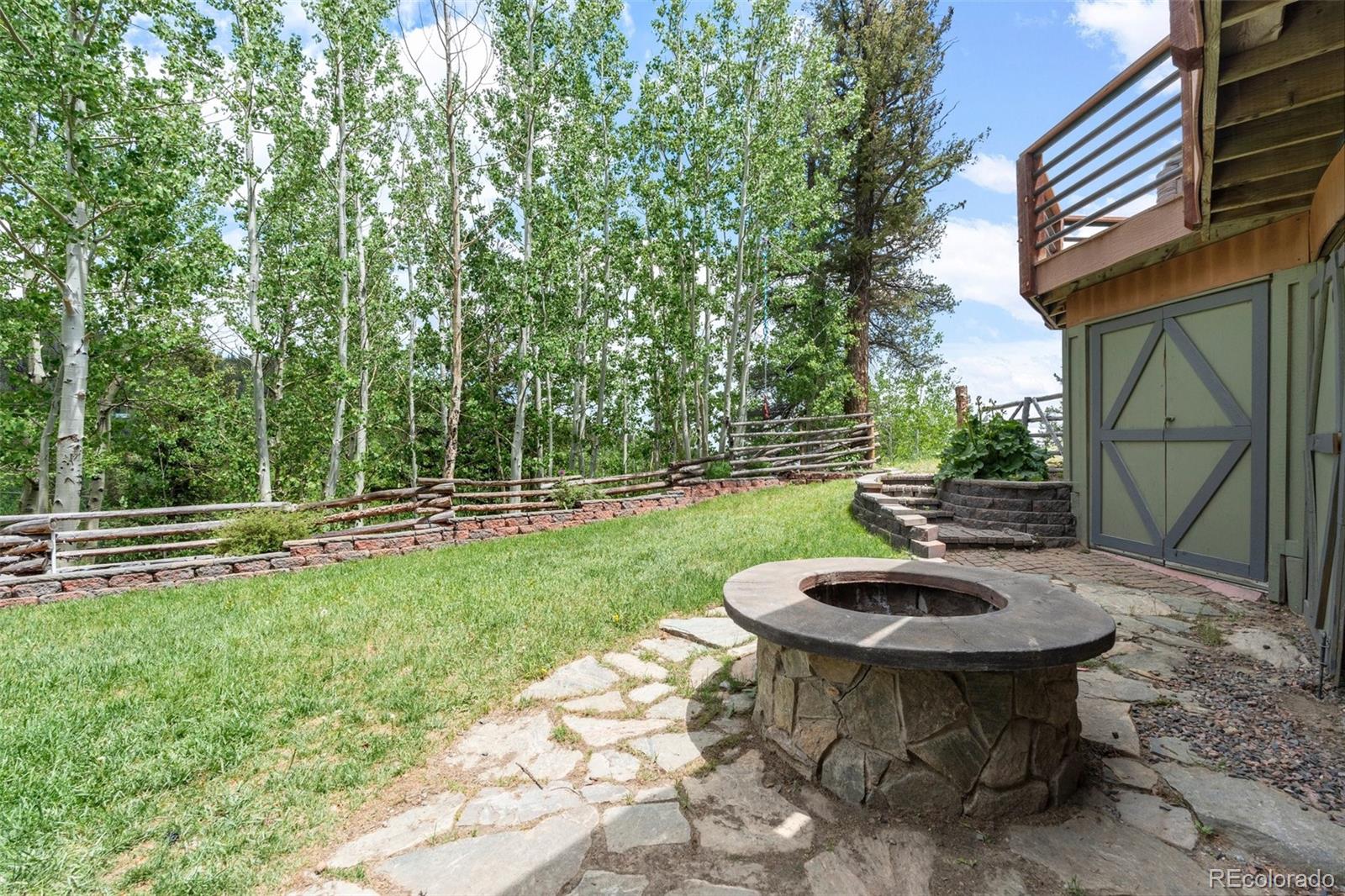 1682 Sinton Road Evergreen, CO 80439 - Photo 16 of 40 a view of a backyard with table and chairs potted plants and wooden fence