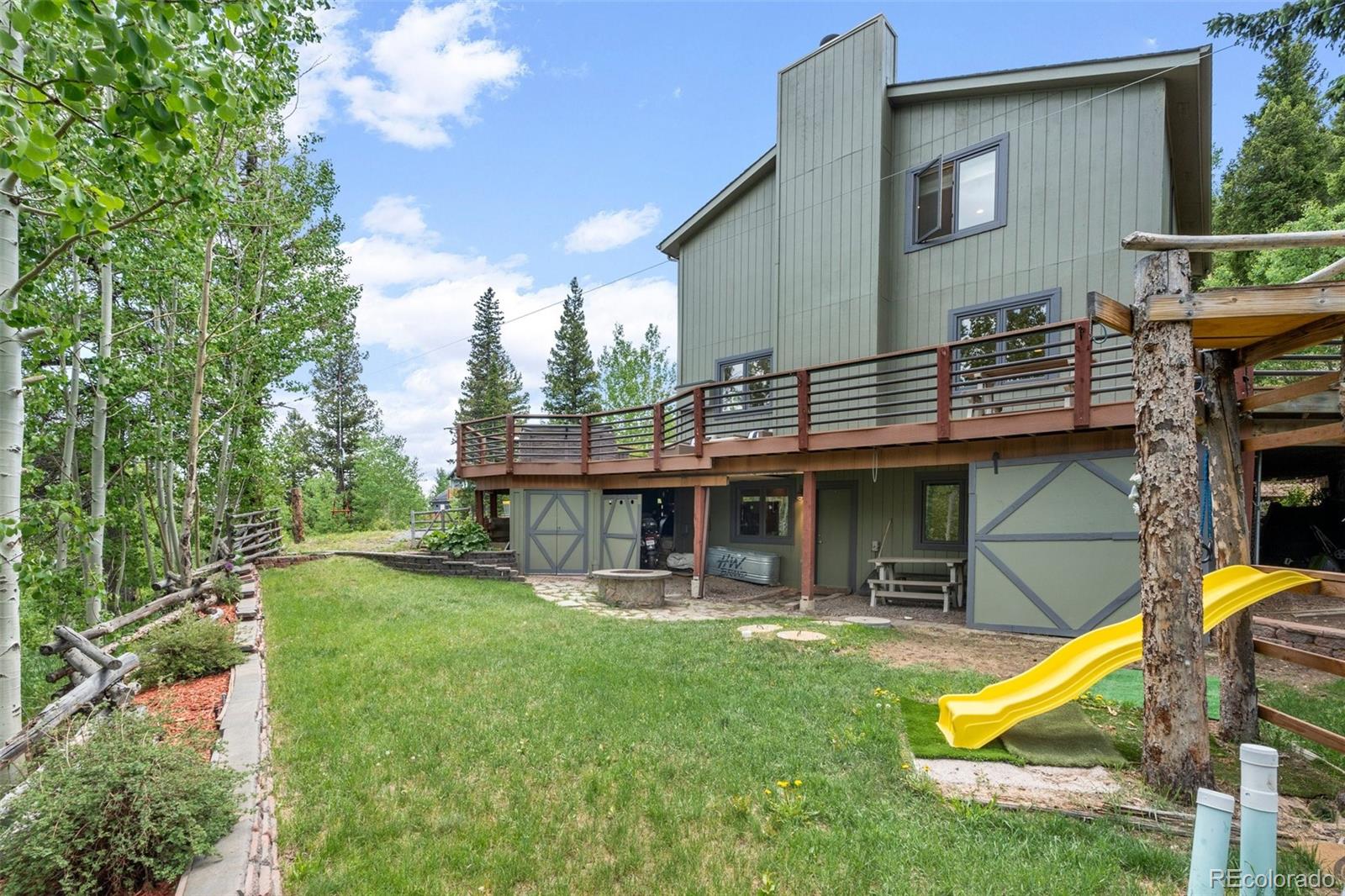 1682 Sinton Road Evergreen, CO 80439 - Photo 17 of 40 a view of a house with backyard porch and wooden fence