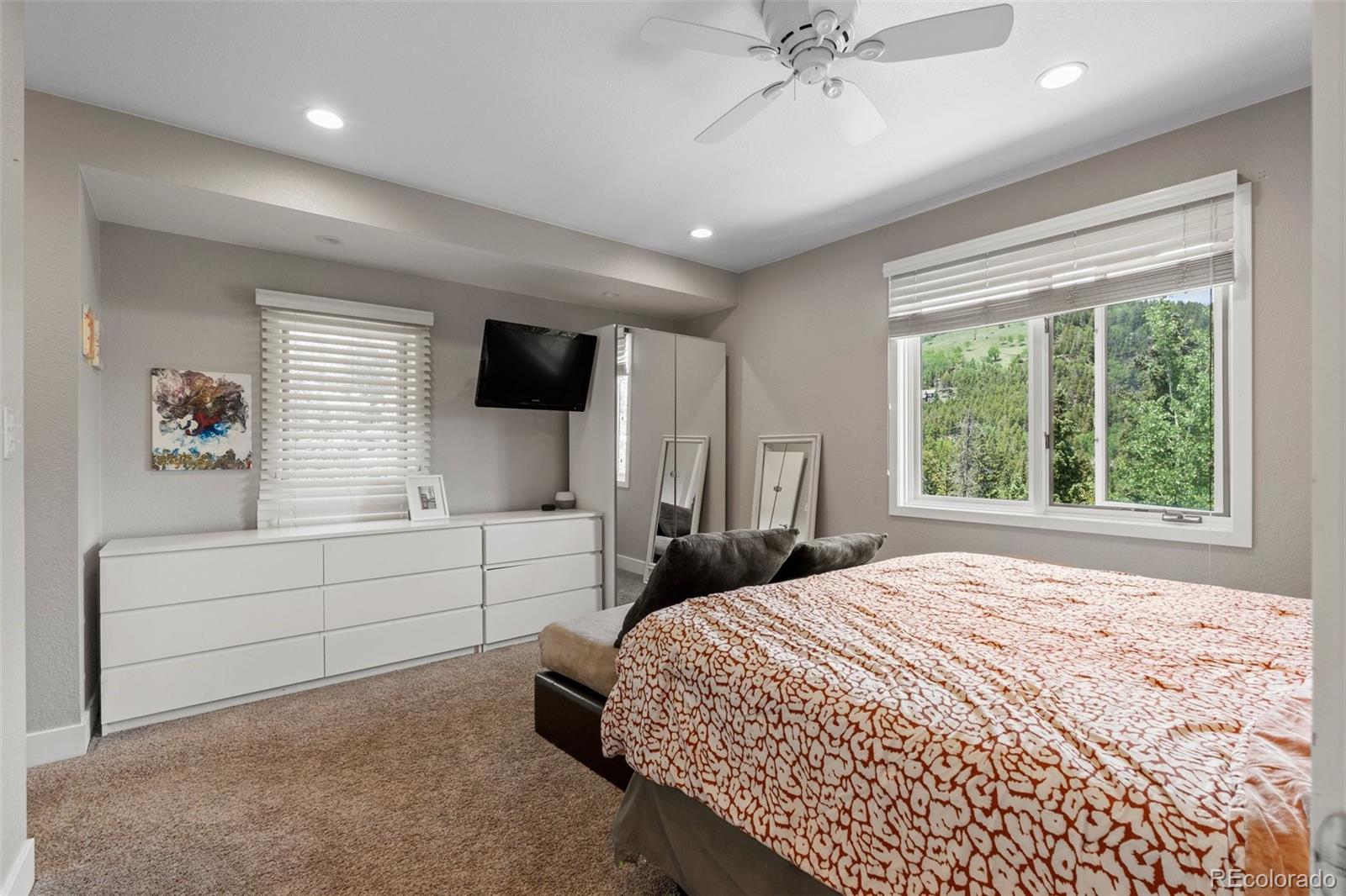 1682 Sinton Road Evergreen, CO 80439 - Photo 21 of 40 a bedroom with a bed and a large window