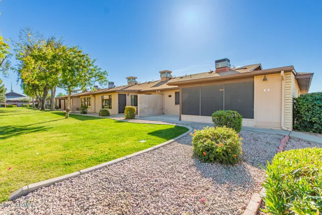 a view of a house with a big yard and palm trees