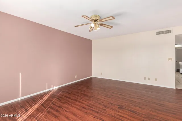 a view of a room with wooden floor and a ceiling fan