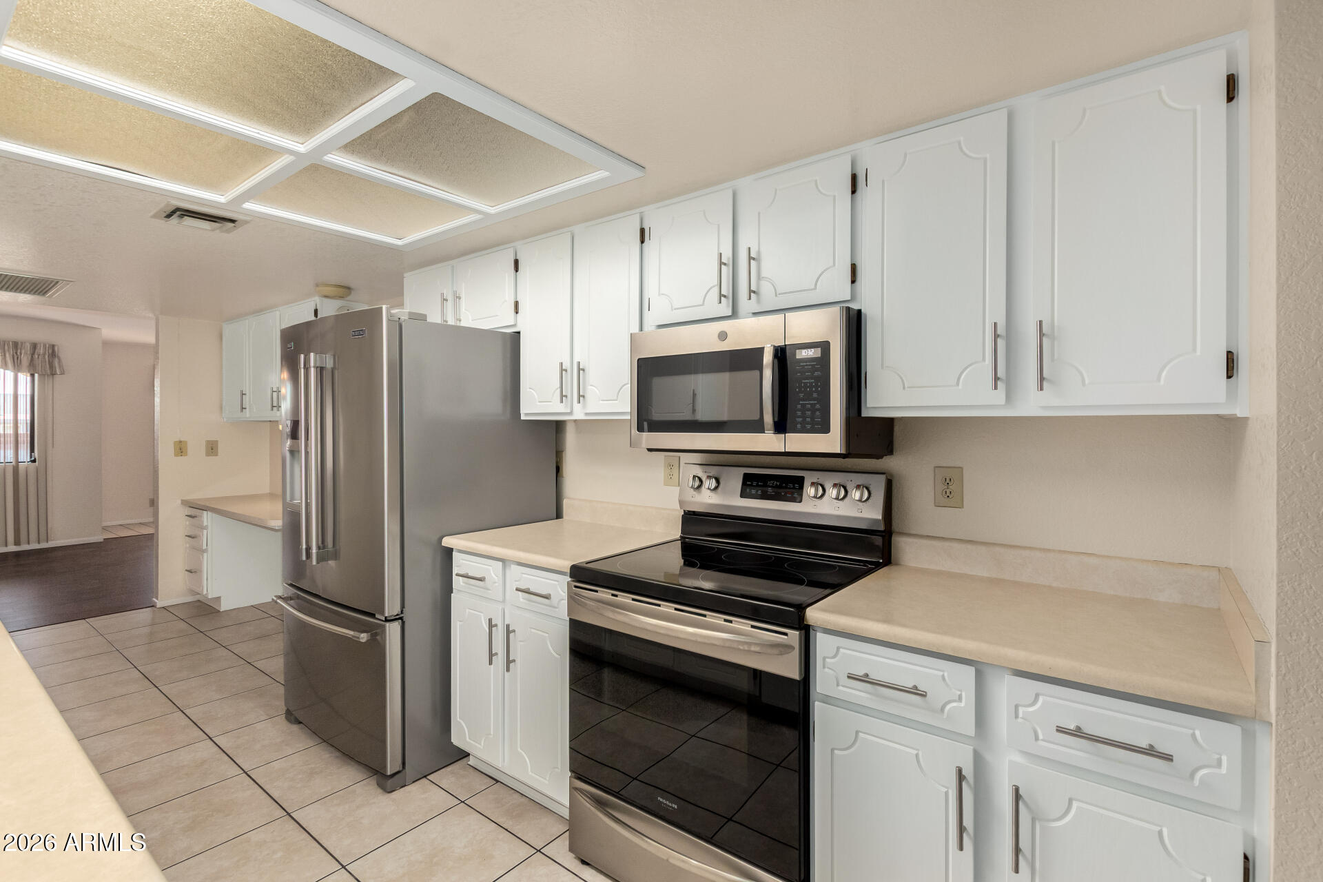 520 South Greenfield Road, Unit 30 Mesa, AZ 85206 - Photo 10 of 29 a kitchen with stainless steel appliances a refrigerator stove and white cabinets