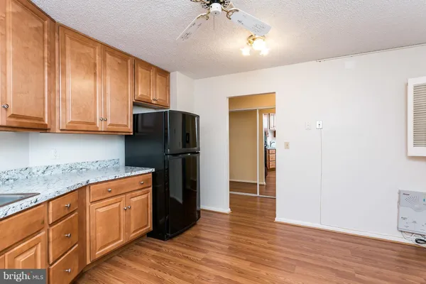 a kitchen with stainless steel appliances granite countertop a refrigerator and a stove top oven