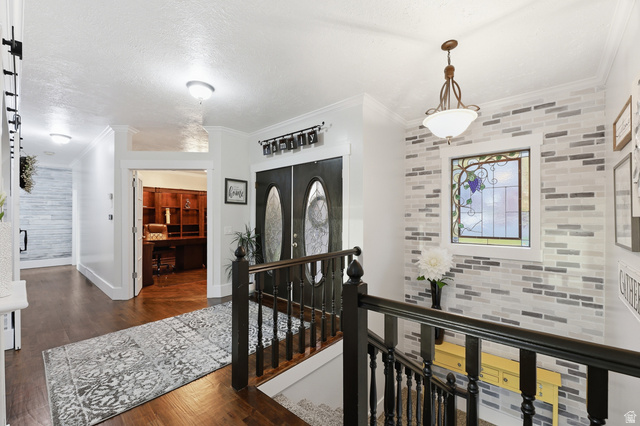 2342 Charros Road Sandy, UT 84092 - Photo 8 of 94 Entryway featuring a wood-finish floor, a decorative stained-glass window, and a dark wood banister