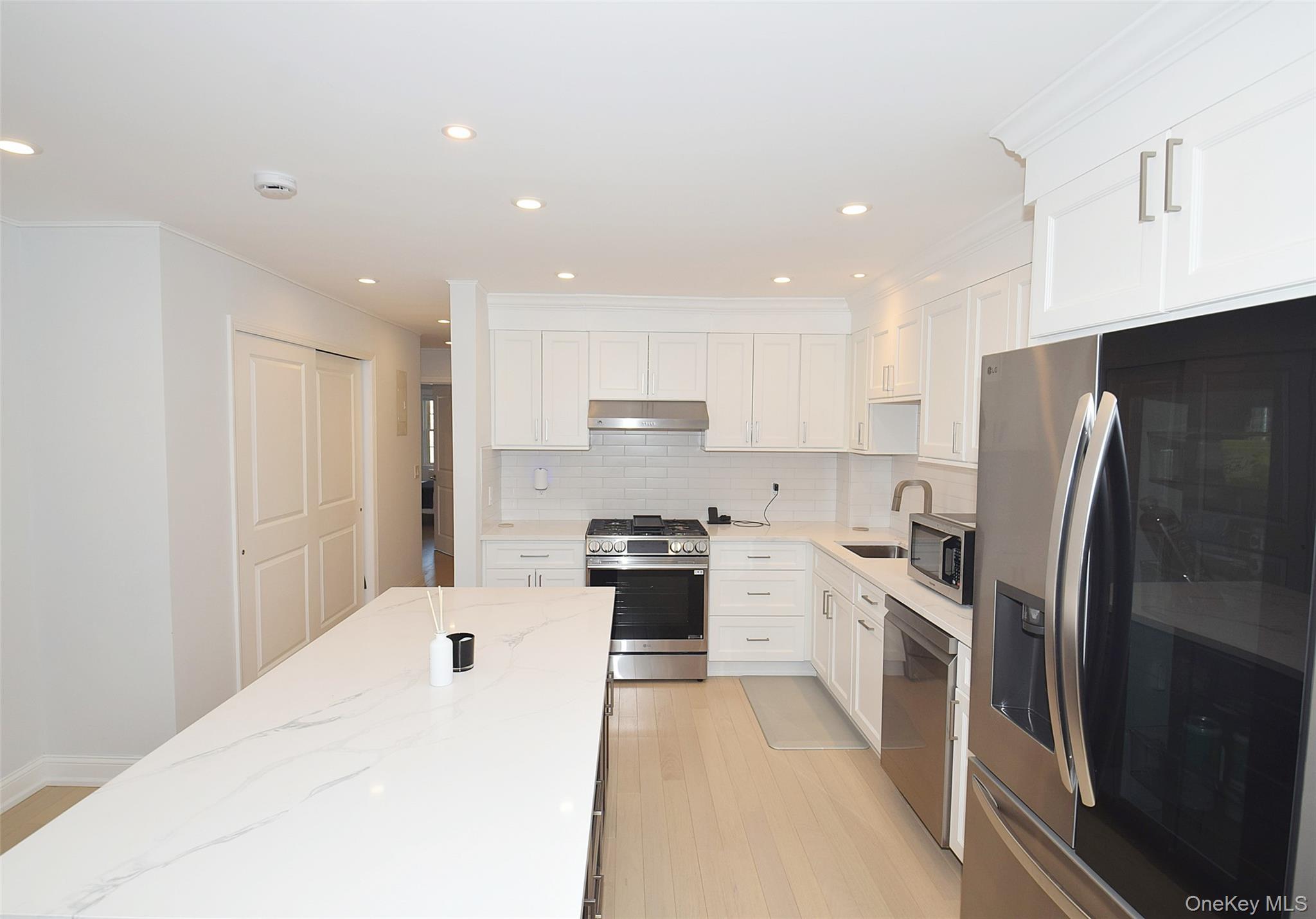 208-08 Robert Road, Unit 191M Queens, NY 11360 - Photo 12 of 37 a kitchen with stainless steel appliances granite countertop a refrigerator sink and stove