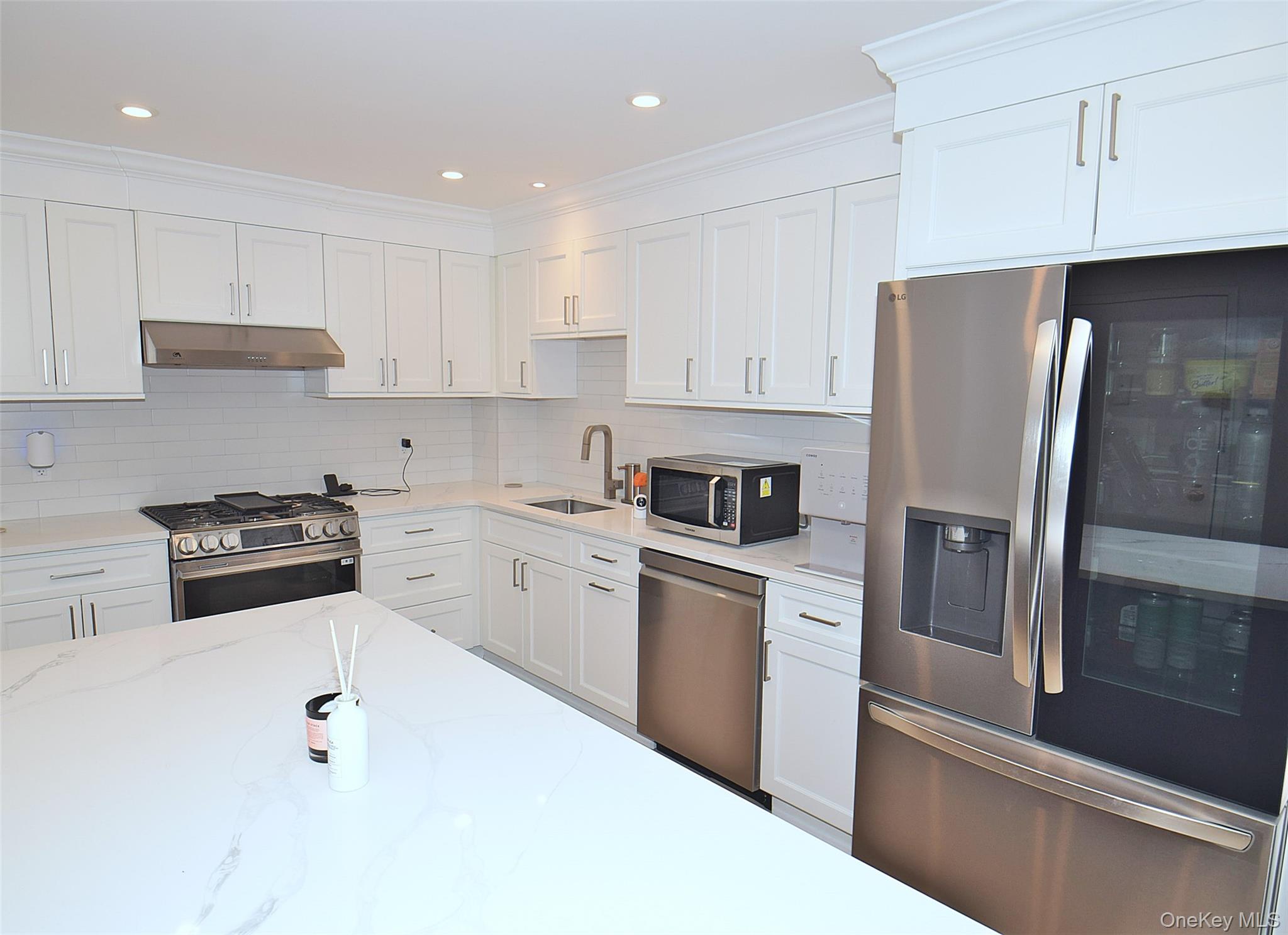 208-08 Robert Road, Unit 191M Queens, NY 11360 - Photo 13 of 37 a kitchen with stainless steel appliances a refrigerator sink and cabinets