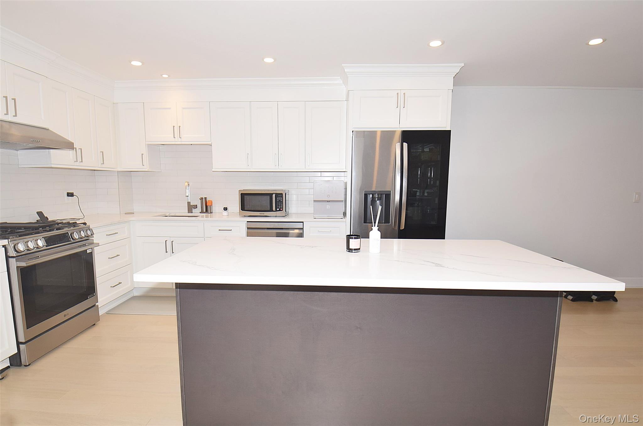 208-08 Robert Road, Unit 191M Queens, NY 11360 - Photo 14 of 37 a kitchen with stainless steel appliances a refrigerator sink and stove
