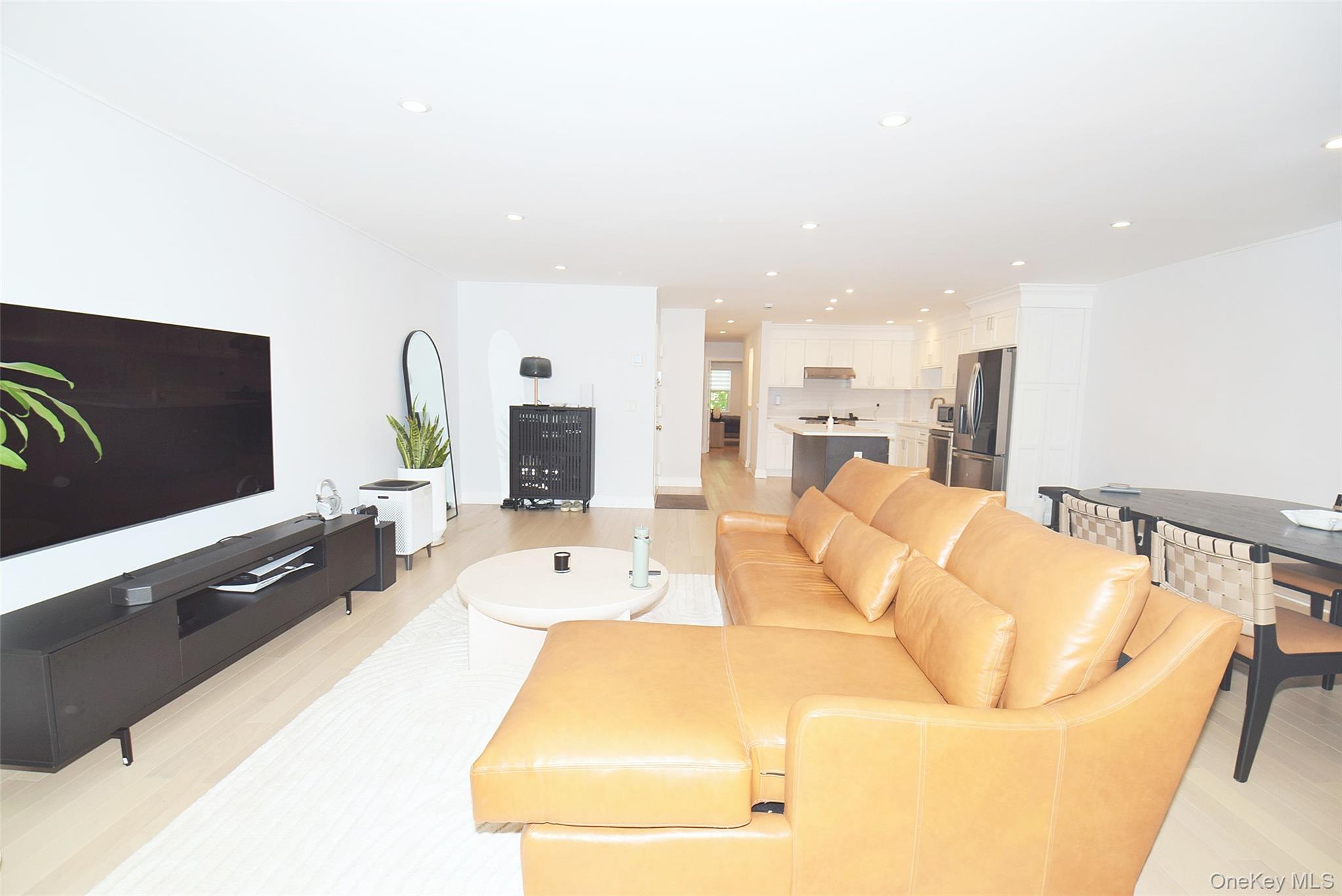 208-08 Robert Road, Unit 191M Queens, NY 11360 - Photo 16 of 37 a living room with furniture and a flat screen tv