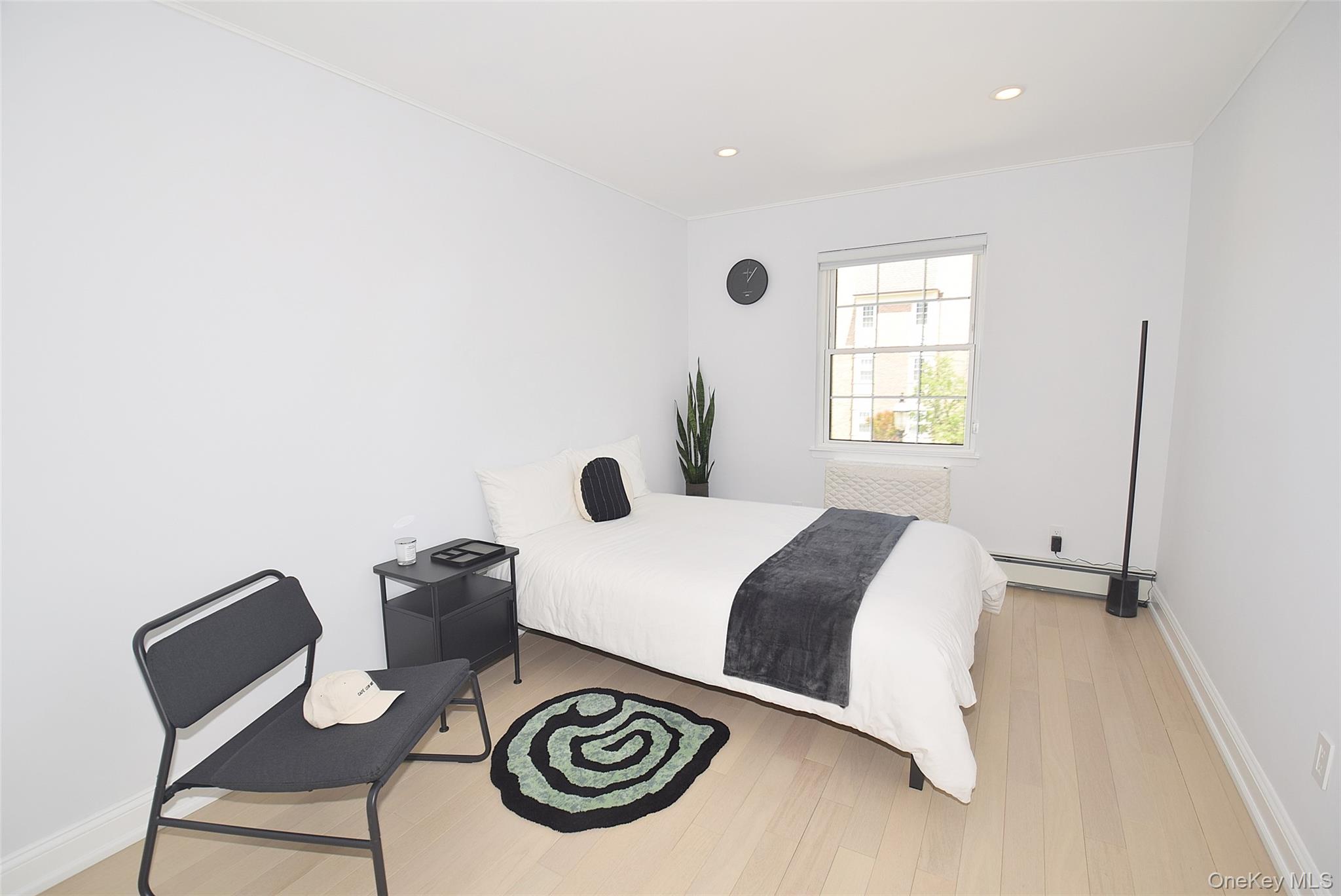 208-08 Robert Road, Unit 191M Queens, NY 11360 - Photo 20 of 37 a bedroom with a bed and a chair