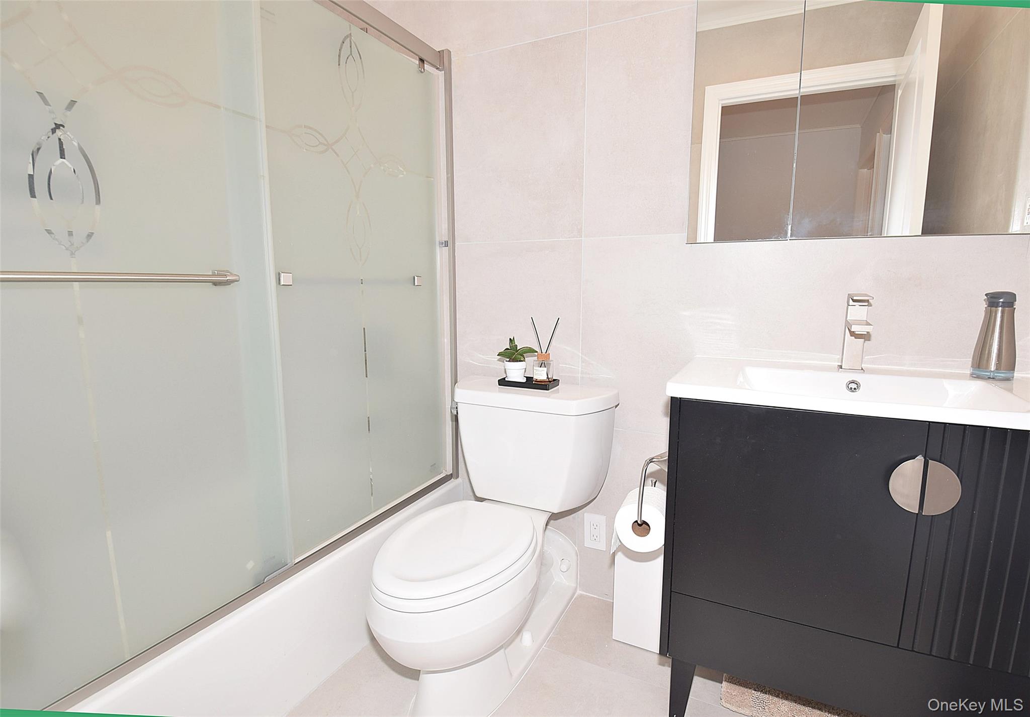 208-08 Robert Road, Unit 191M Queens, NY 11360 - Photo 22 of 37 a bathroom with a sink a toilet a mirror and vanity