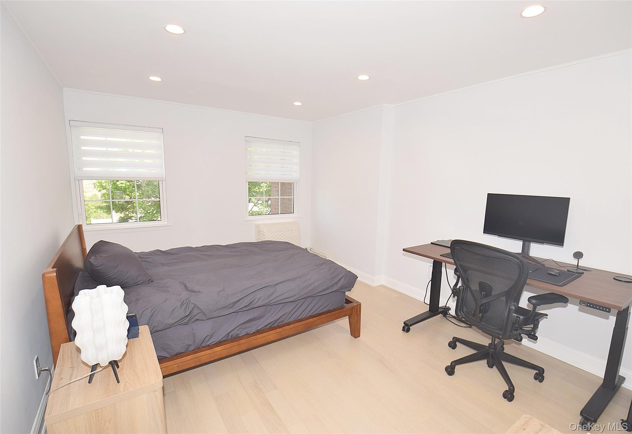 208-08 Robert Road, Unit 191M Queens, NY 11360 - Photo 23 of 37 a bedroom with a bed and a desk