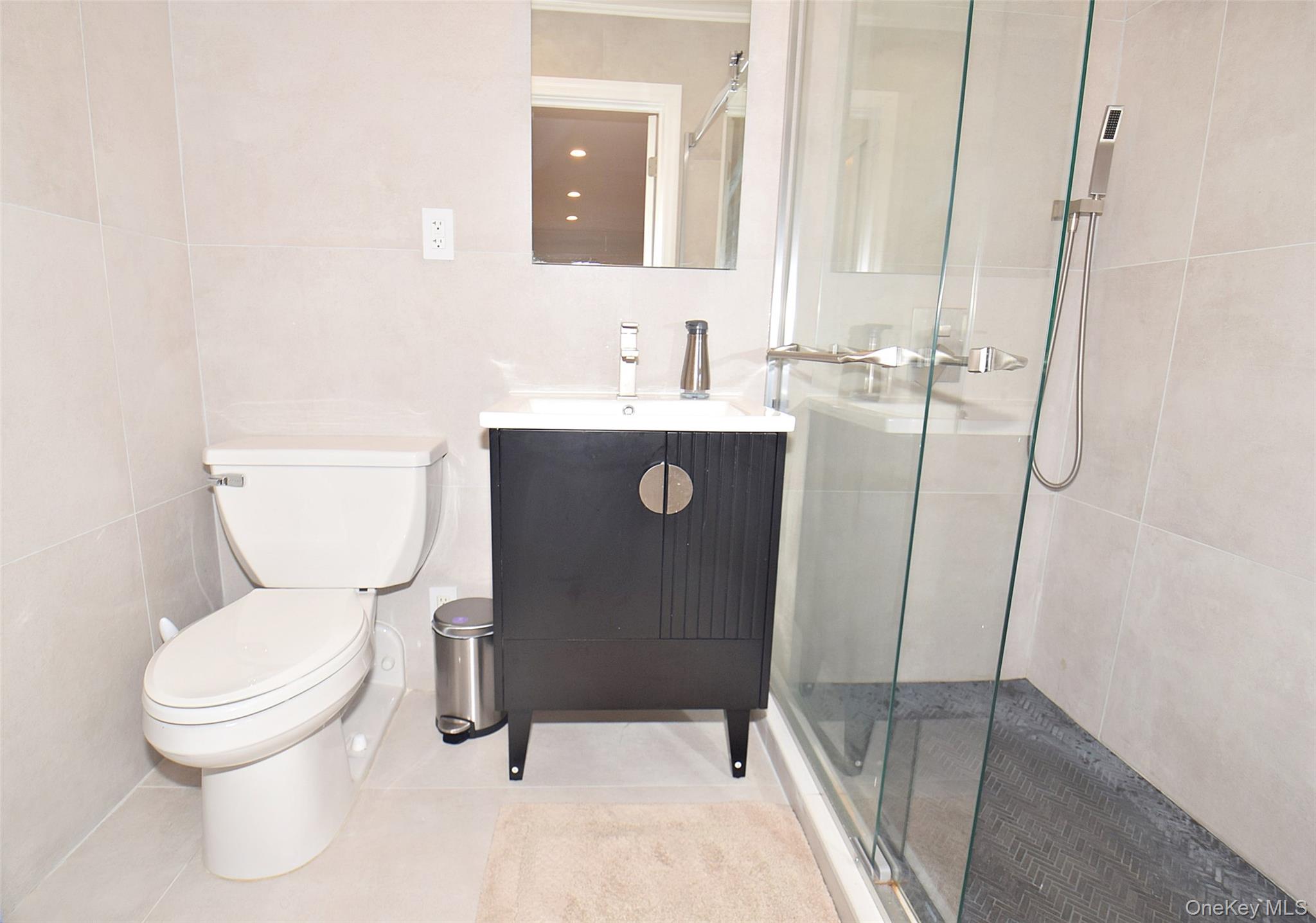 208-08 Robert Road, Unit 191M Queens, NY 11360 - Photo 24 of 37 a bathroom with a toilet sink and a mirror