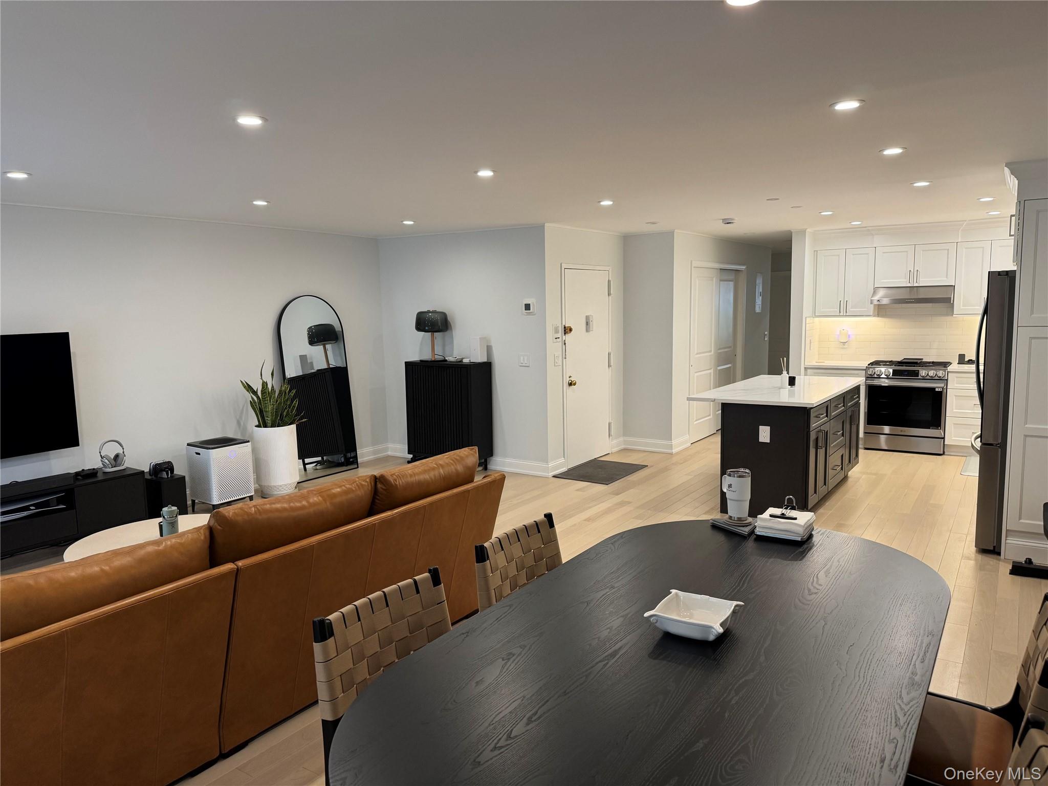 208-08 Robert Road, Unit 191M Queens, NY 11360 - Photo 4 of 37 a living room with furniture and a flat screen tv