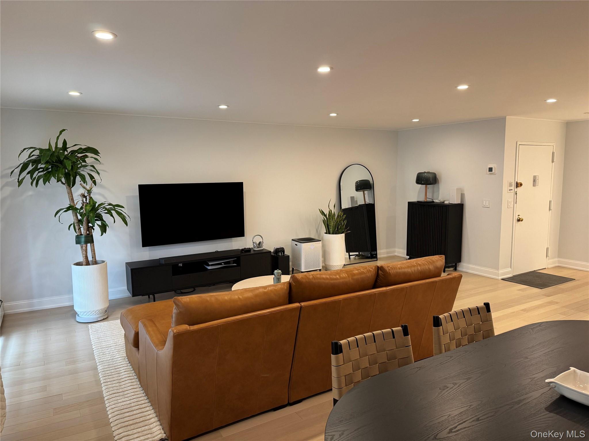 208-08 Robert Road, Unit 191M Queens, NY 11360 - Photo 5 of 37 a living room with furniture and a flat screen tv