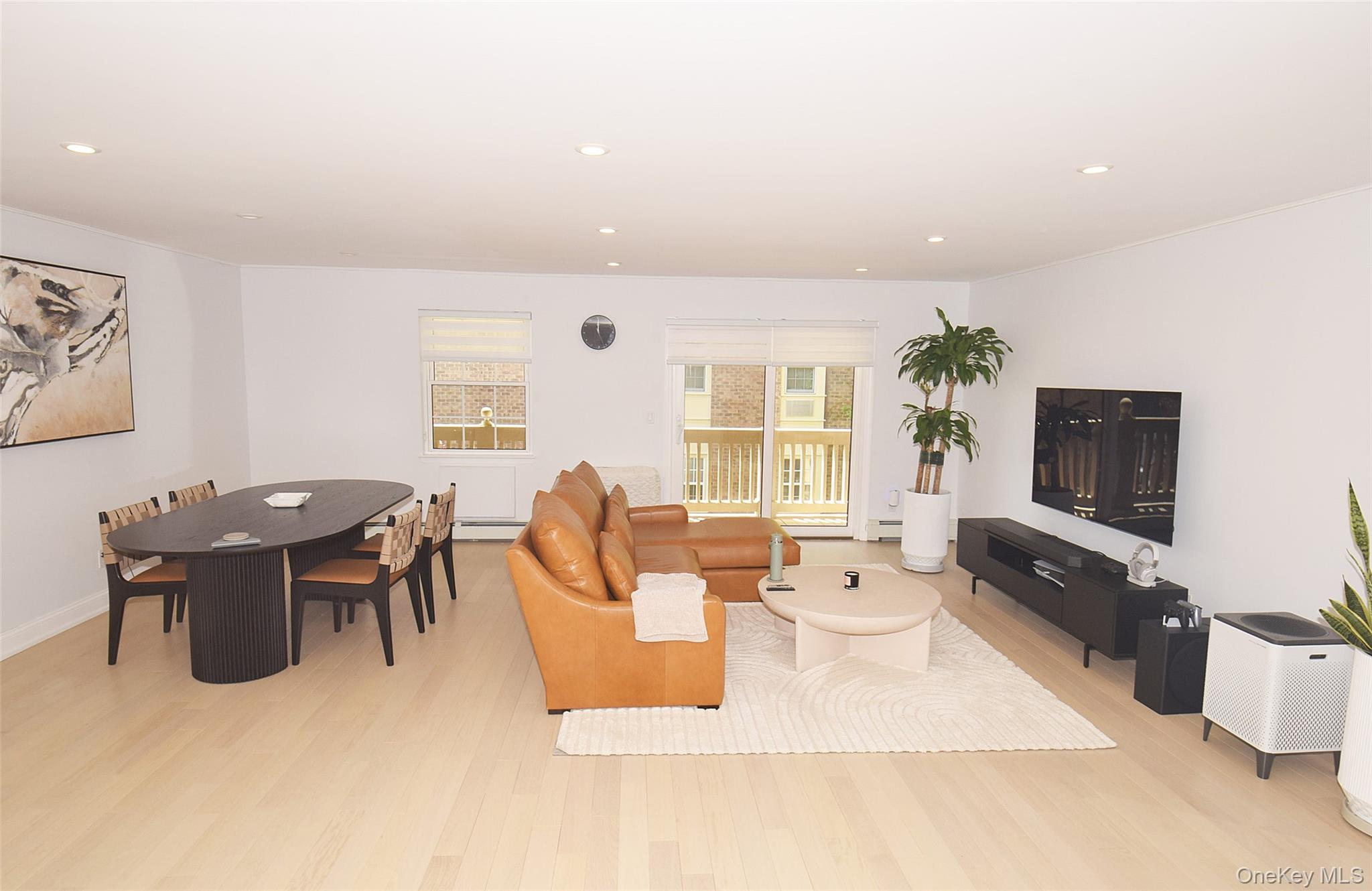 208-08 Robert Road, Unit 191M Queens, NY 11360 - Photo 9 of 37 a living room with lots of furniture and a flat screen tv