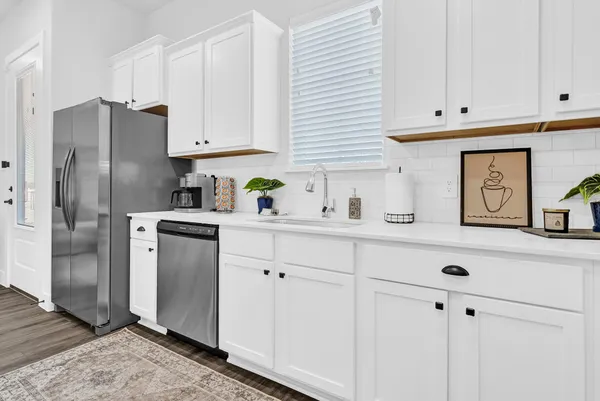 a kitchen with stainless steel appliances white cabinets and a refrigerator