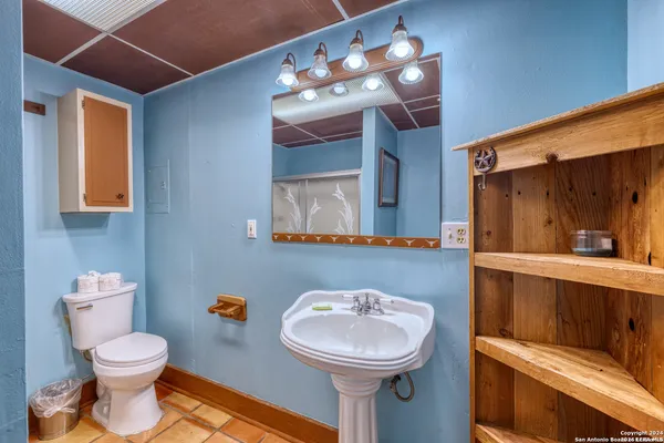 a bathroom with a sink mirror and toilet