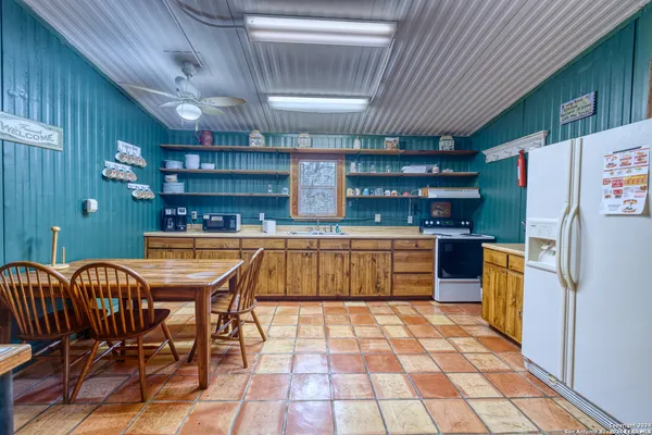a kitchen with a table chairs and refrigerator