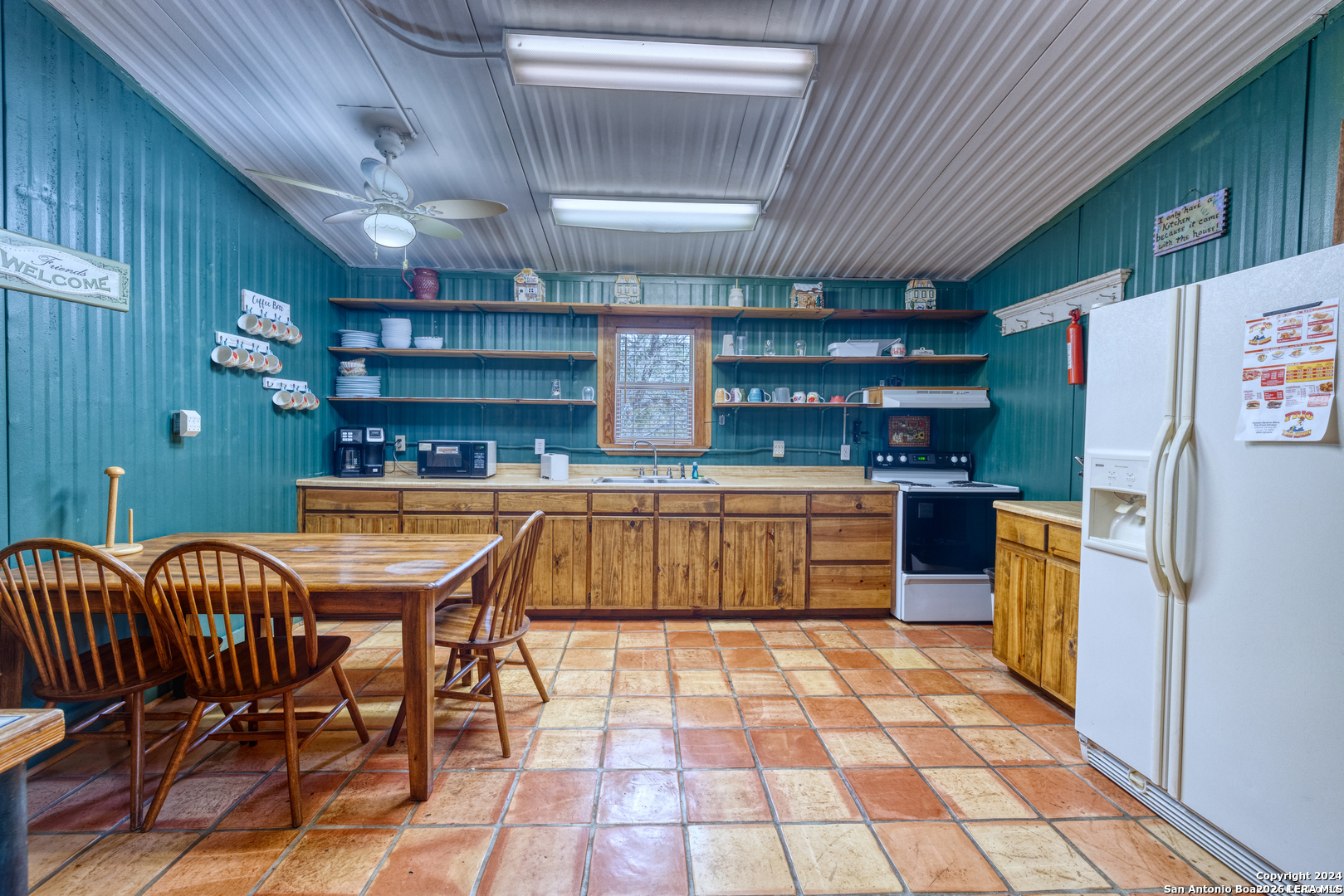 711 Mariposa Concan, TX 78838 - Photo 6 of 23 a kitchen with a table chairs and refrigerator