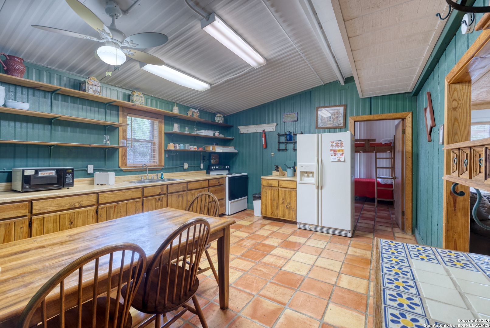 711 Mariposa Concan, TX 78838 - Photo 7 of 23 a kitchen with stainless steel appliances kitchen island granite countertop a refrigerator a sink a stove and island