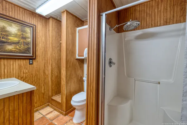 a bathroom with a granite countertop sink mirror vanity and toilet
