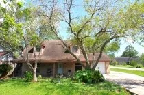 a view of an house with backyard and a tree