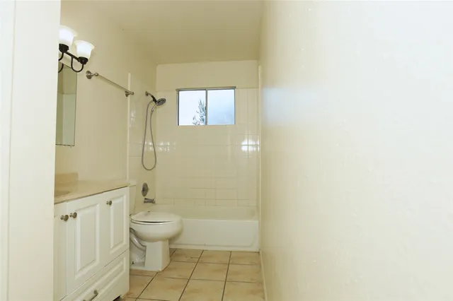 a bathroom with a granite countertop sink a toilet and shower