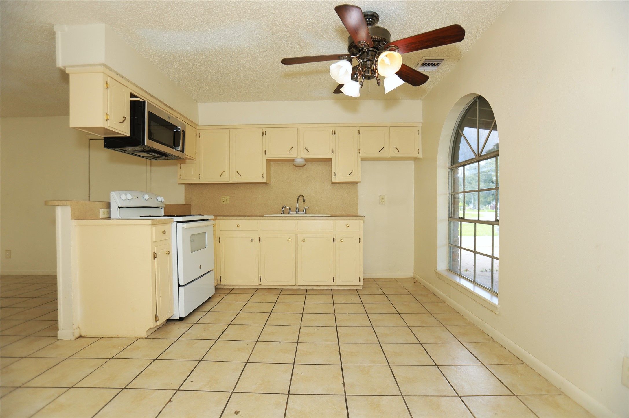 1131 Gifford Road Angleton, TX 77515 - Photo 4 of 14 a view of a kitchen with cabinets appliances and a ceiling fan