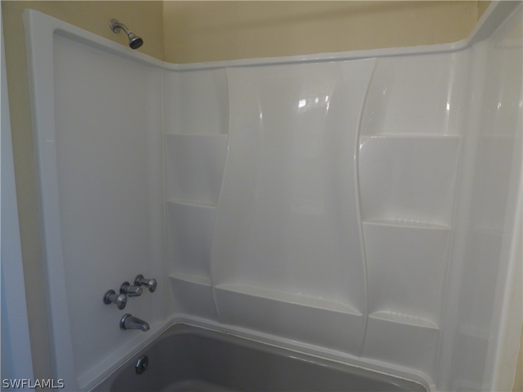 307 East Penn Road Lehigh Acres, FL 33936 - Photo 20 of 20 a bathroom with a shower and a bathtub