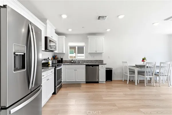 a kitchen with stainless steel appliances kitchen island granite countertop a refrigerator and a stove top oven