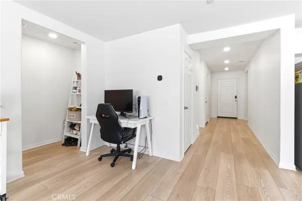 a view of a workspace with wooden floor and furniture