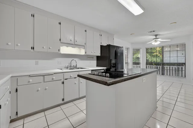 a kitchen with white cabinets a sink and dishwasher