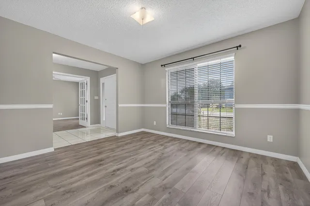 a view of an empty room with wooden floor