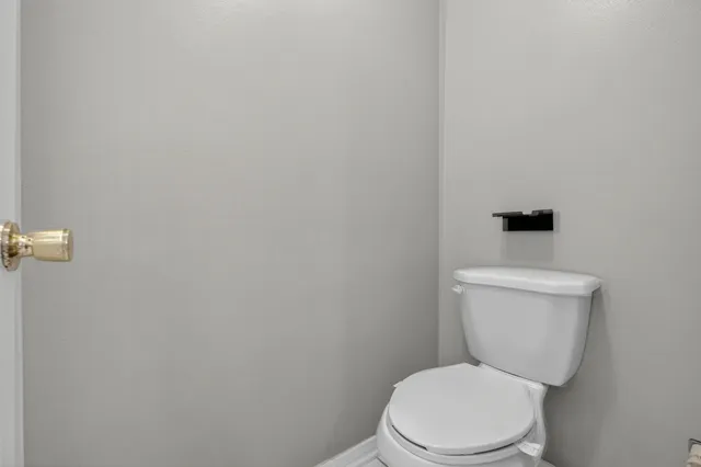 a view of an empty room with a cabinet and mirrors