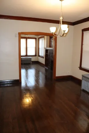 a view of a livingroom with a large window and wooden floor