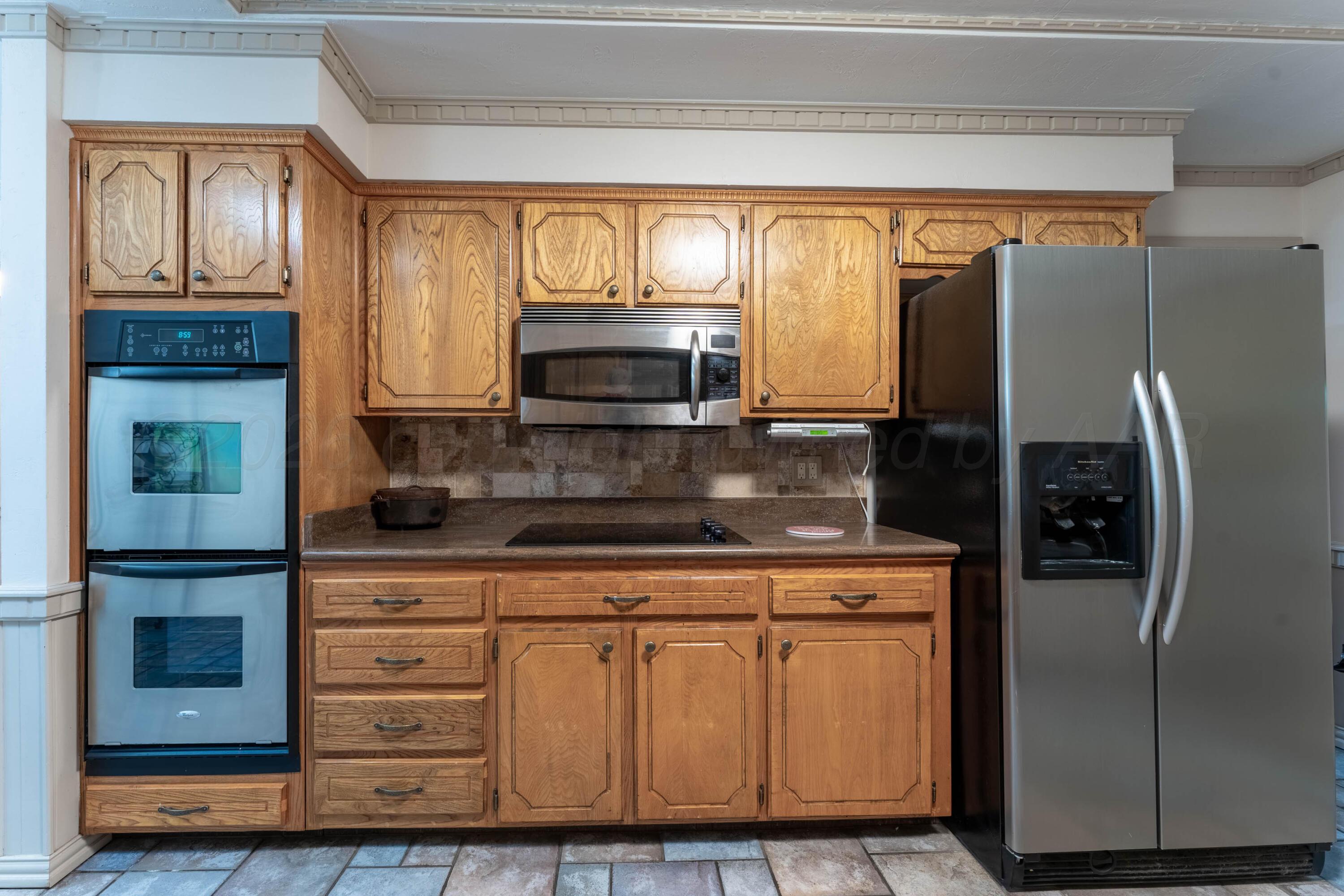 6606 Drexel Road Amarillo, TX 79109 - Photo 17 of 44 a kitchen with granite countertop a refrigerator stove and microwave