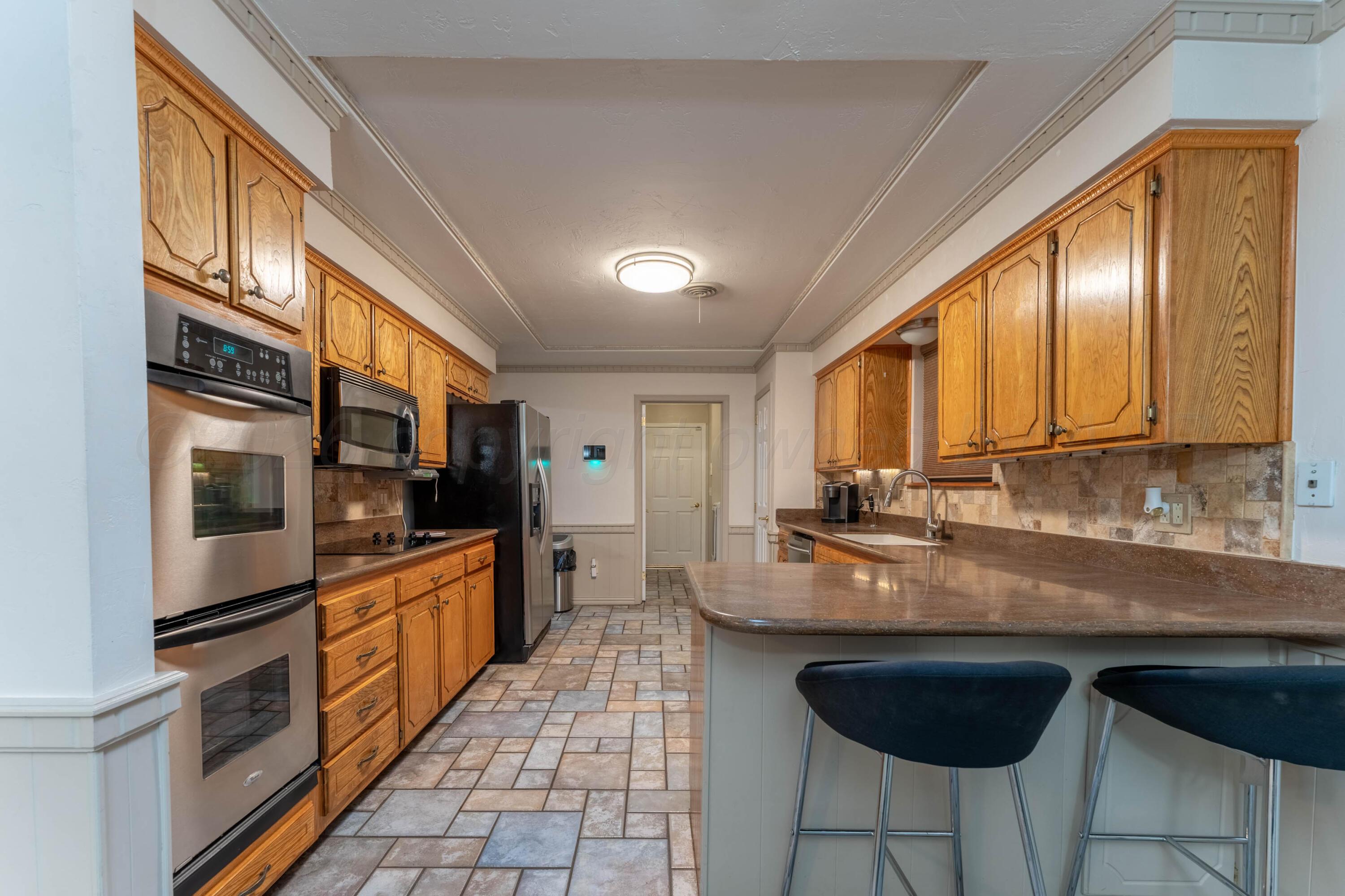 6606 Drexel Road Amarillo, TX 79109 - Photo 18 of 44 a kitchen with stainless steel appliances granite countertop a stove a sink and a microwave