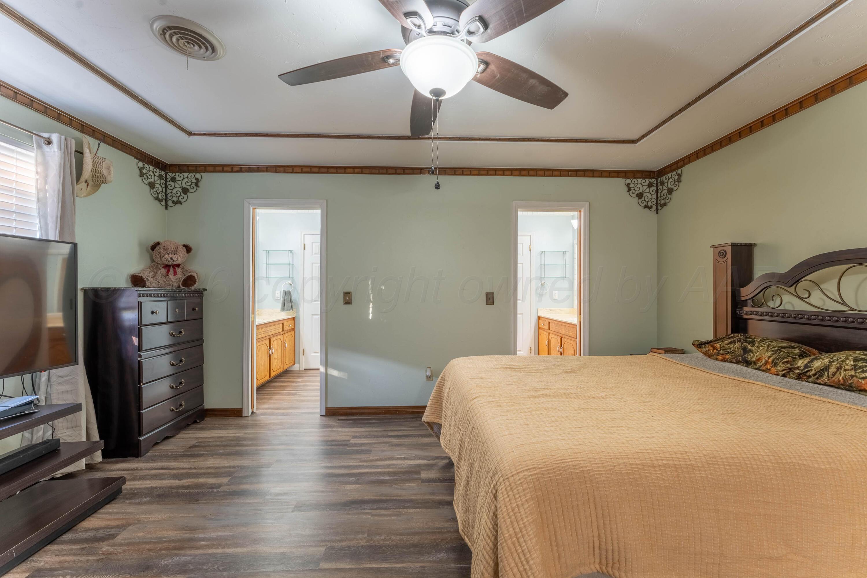 6606 Drexel Road Amarillo, TX 79109 - Photo 24 of 44 a bedroom with a bed and a chandelier