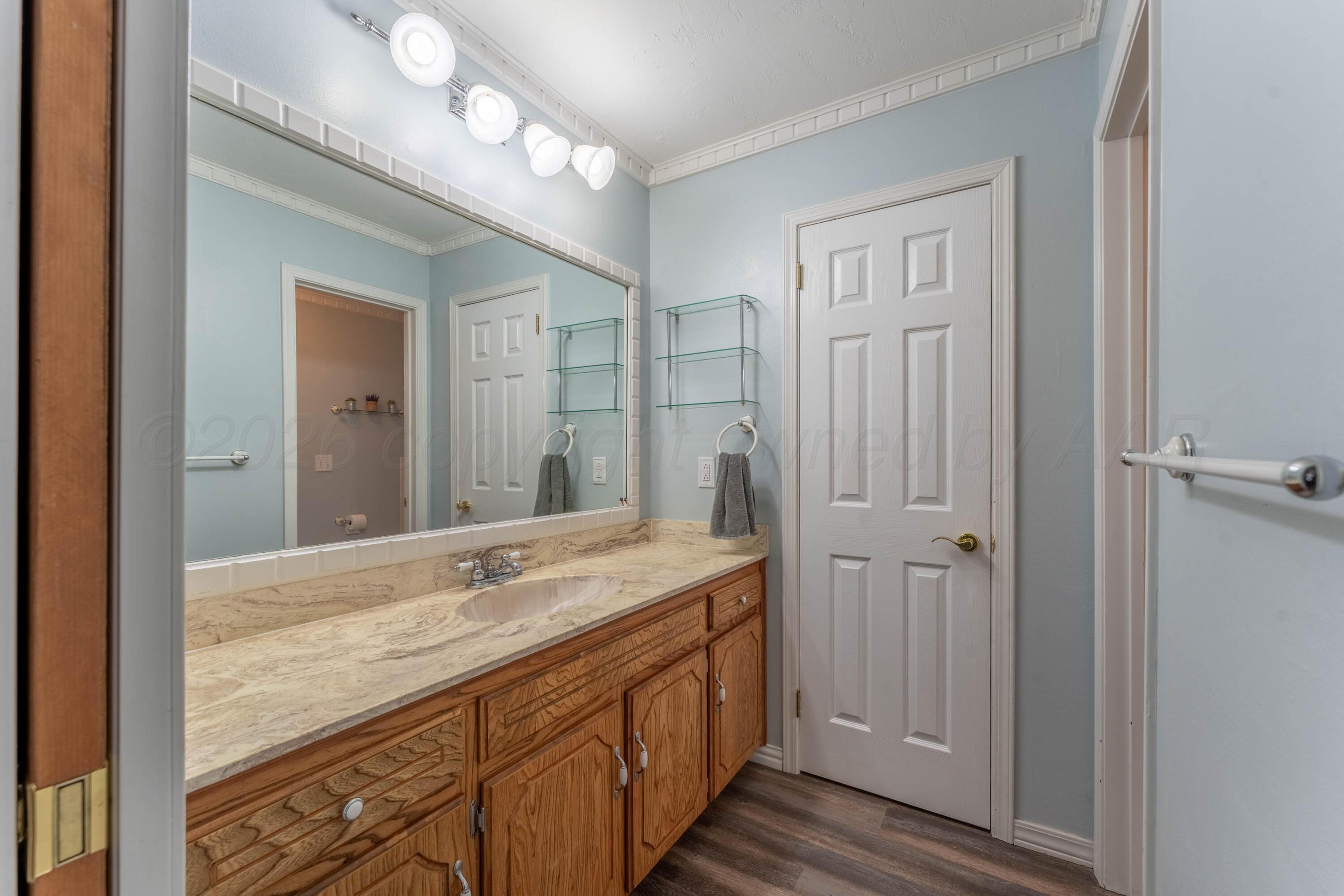 6606 Drexel Road Amarillo, TX 79109 - Photo 27 of 44 a bathroom with a granite countertop sink and a mirror