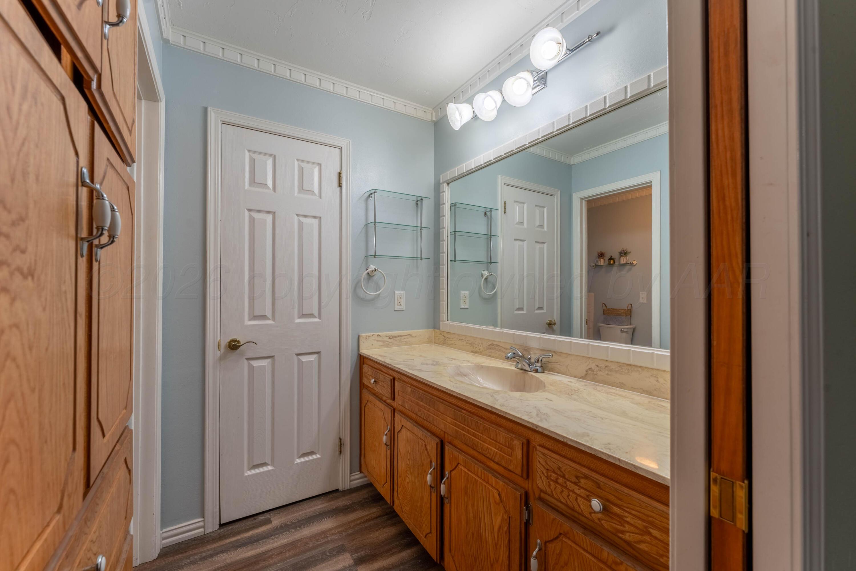 6606 Drexel Road Amarillo, TX 79109 - Photo 31 of 44 a bathroom with a granite countertop sink a large mirror and a shower