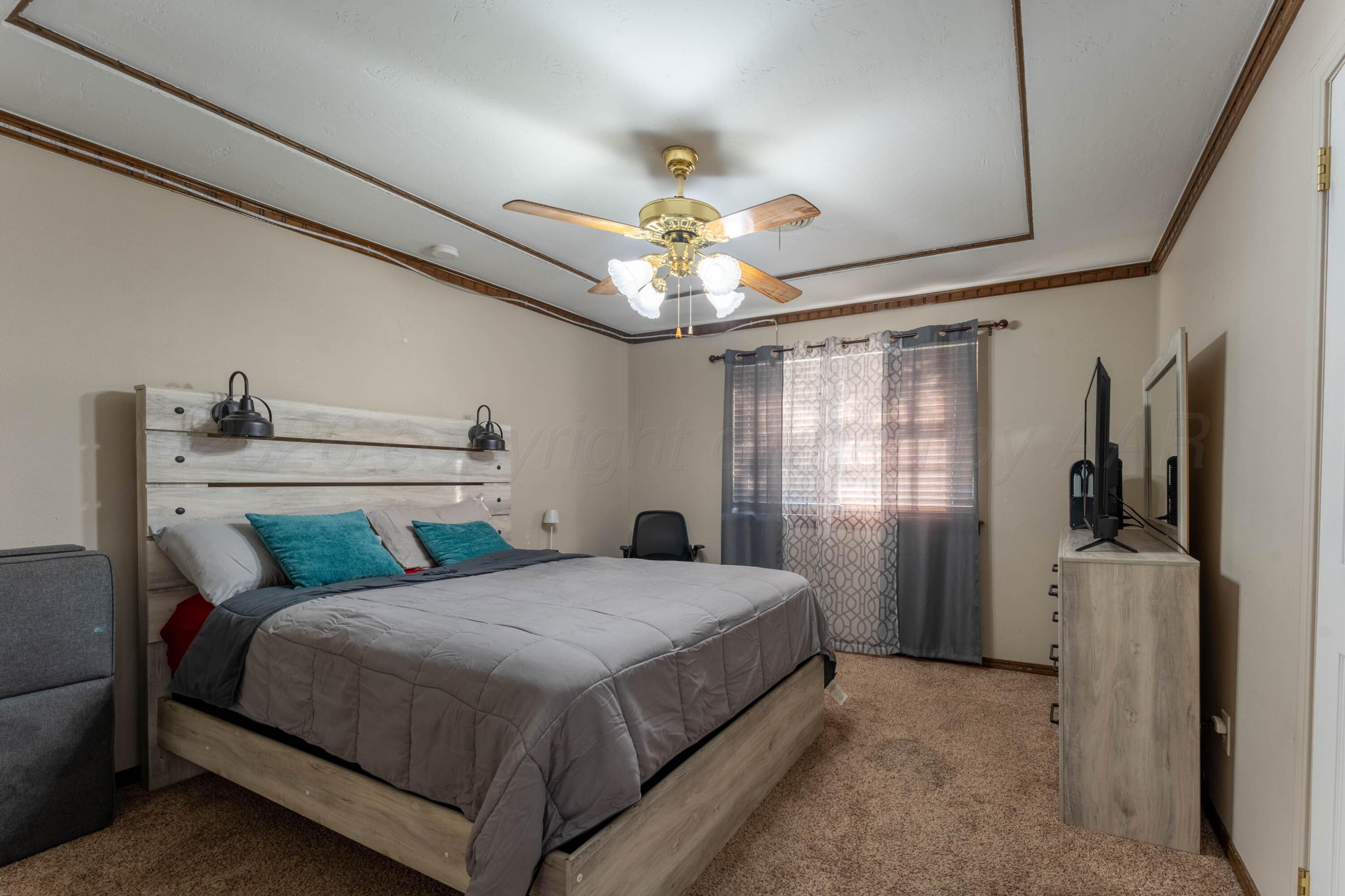 6606 Drexel Road Amarillo, TX 79109 - Photo 32 of 44 a bedroom with a bed and a chandelier