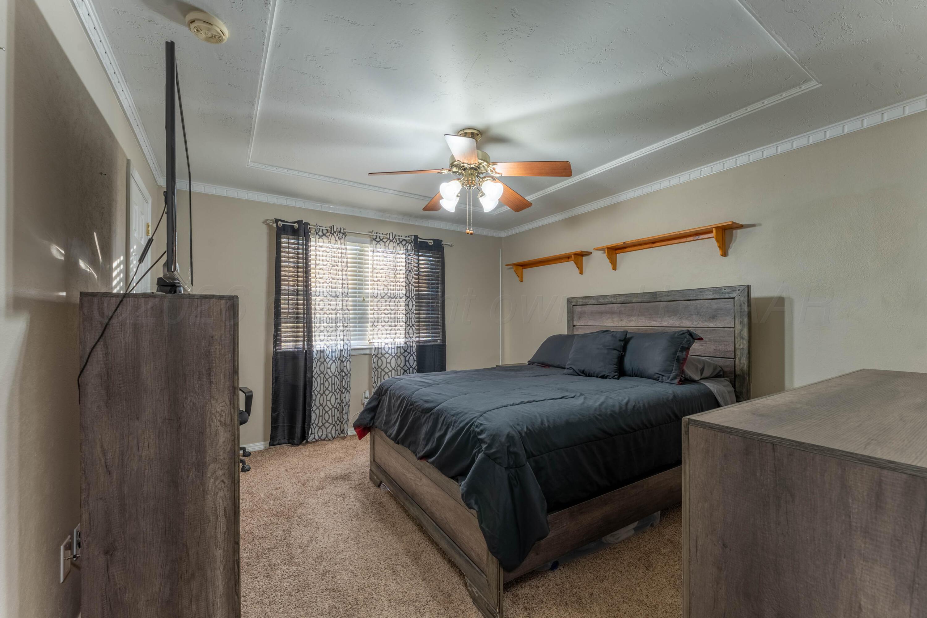 6606 Drexel Road Amarillo, TX 79109 - Photo 35 of 44 a bedroom with a bed lamp and a large window