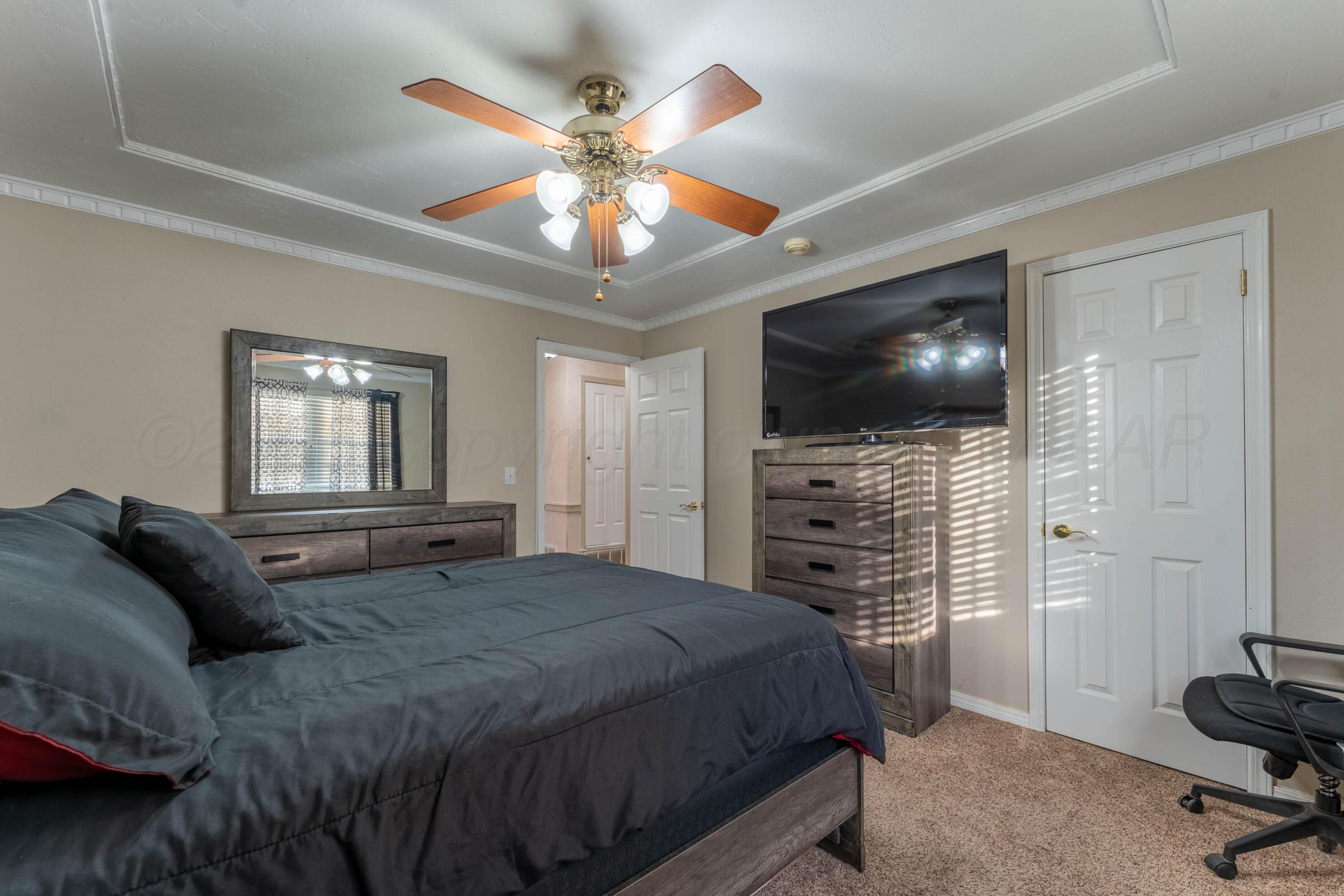 6606 Drexel Road Amarillo, TX 79109 - Photo 36 of 44 a spacious bedroom with a bed and a flat screen tv