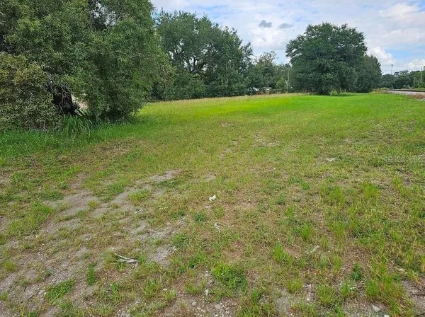 a view of a green field with wooden fence