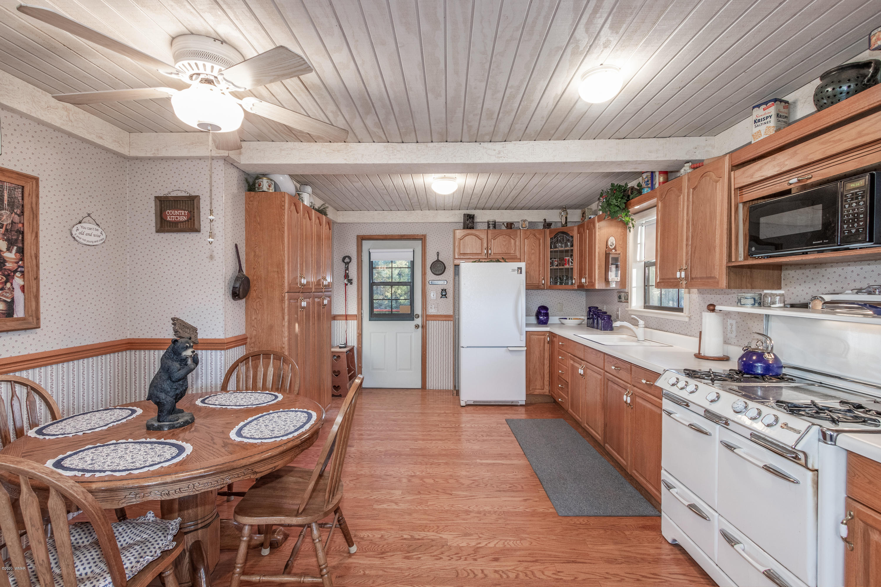 1939 Artist Draw Road Heber, AZ 85928 - Photo 9 of 40 a large kitchen with stainless steel appliances granite countertop a stove a sink dishwasher a dining table and chairs with wooden floor