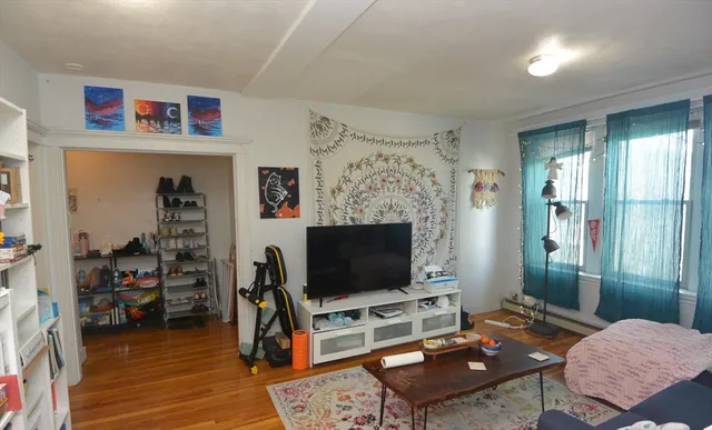 a living room with furniture a flat screen tv and a table